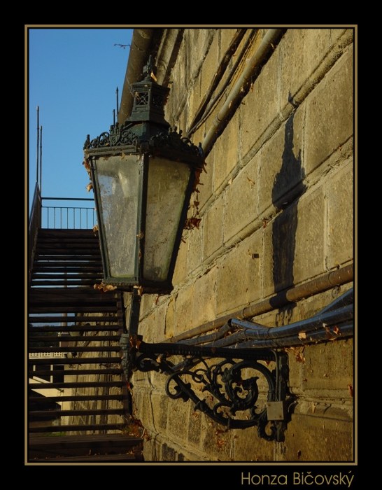 Lampa, nábřeží a modré nebe.