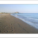 Dlouhé stíny malých kamínků na dlouhé pláži