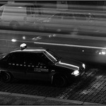 sen o čekající taxislužbě, projíždějící tramvaji a dvou dalších autech