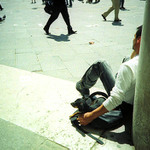 muz se psem u sloupu, v pozadi kracejici lide