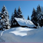 Zasněžená chalupa s kresbou stínu na střeše