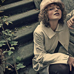 Manekyna v klobuku a kabate, v pozadi schody, nekontrastne to je