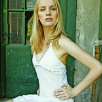 manekyna v bielych satach, sedi, brada mierne nahor, ruky v bok