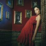 Manekyna v cervenom oblecku, opreta o stenu, divne obrazky