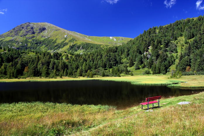 Červená lavička u horského jezera