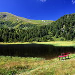 Červená lavička u horského jezera