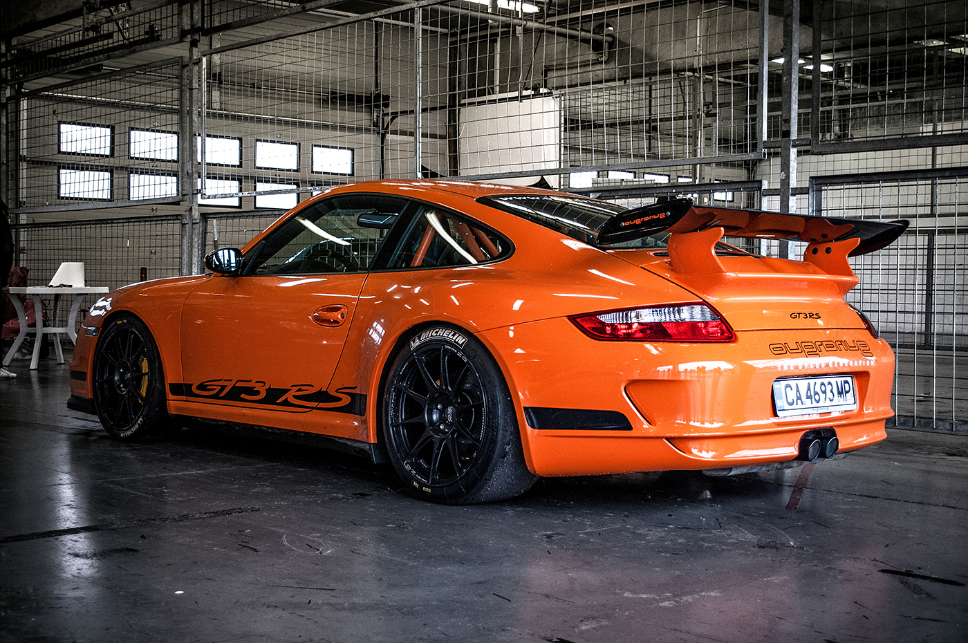 Oranžové závodní Porsche 911 v boxu